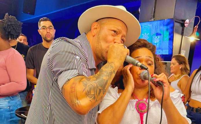 Vagninho cantando com o público ao fundo